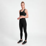 Woman wearing a black athletic outfit on a white background