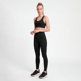 Woman wearing a black athletic outfit on a white background