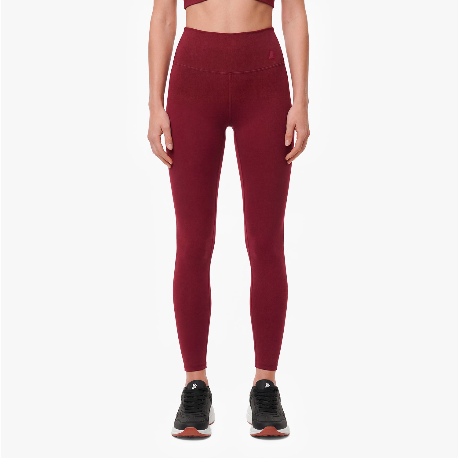 Maroon leggings worn by a person on a white background