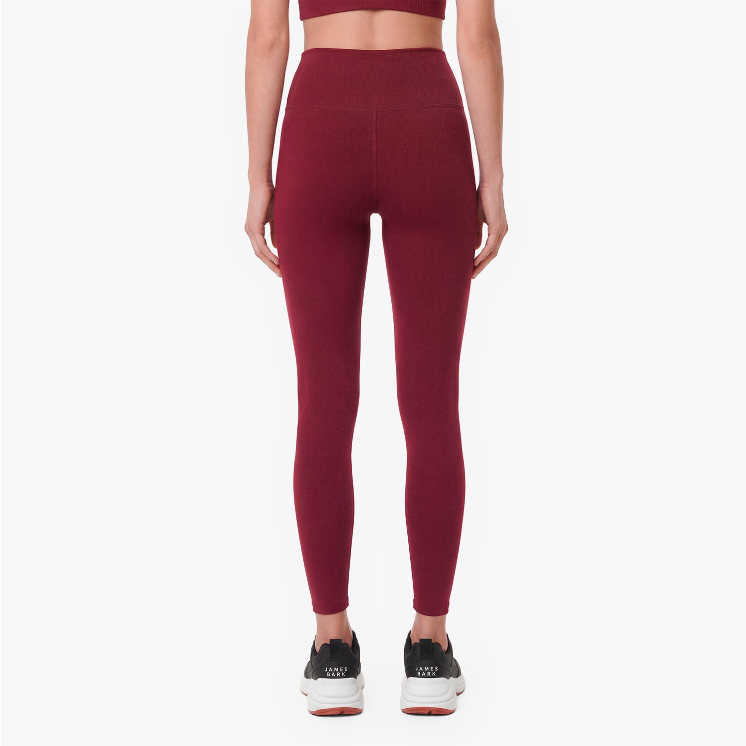 Maroon leggings worn by a person on a white background