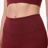 Maroon athletic top and leggings with a brand logo on a white background