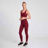 Woman wearing a maroon athletic outfit on a light gray background