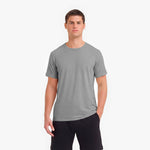 Man wearing a gray t-shirt and black pants on a white background