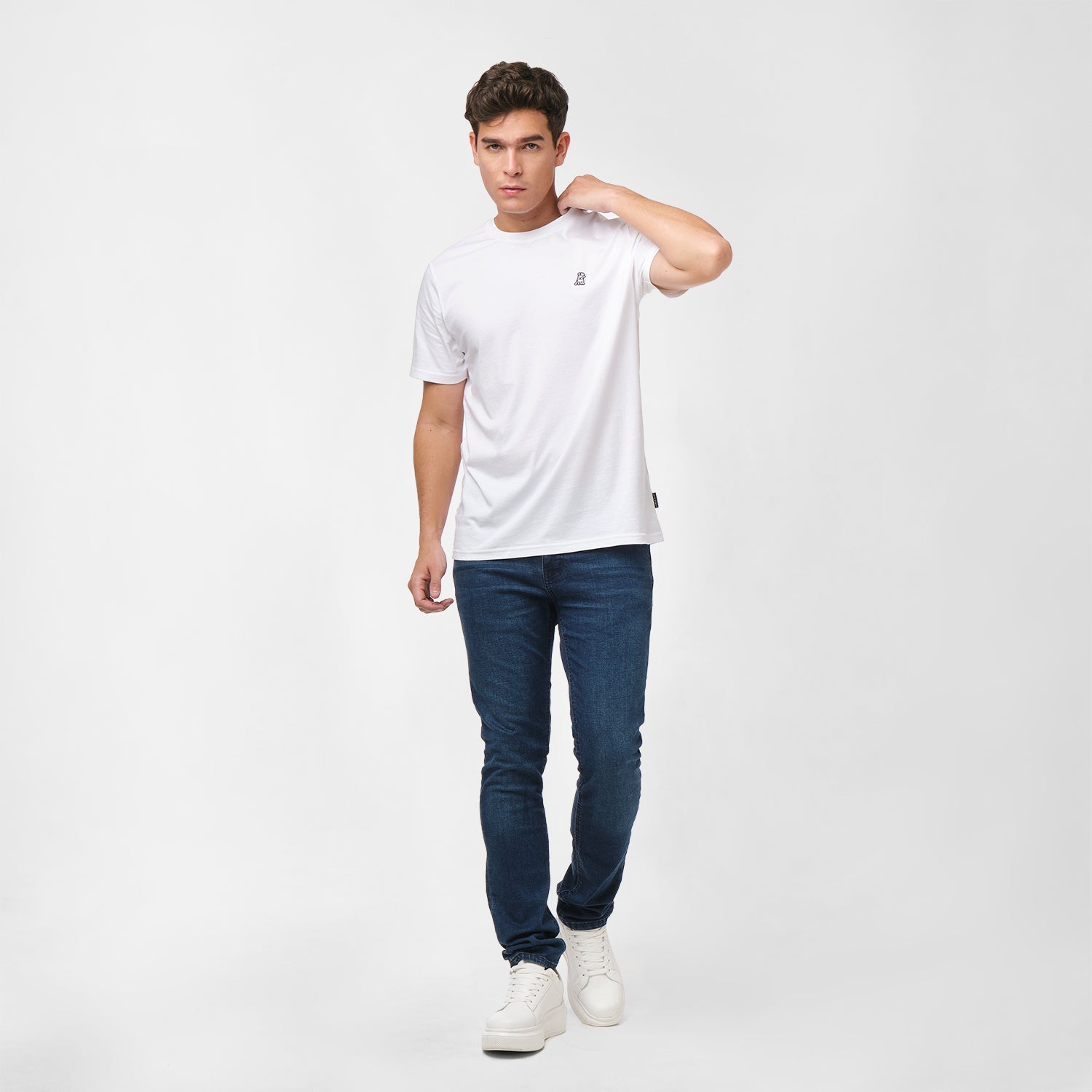 Man wearing a white t-shirt and blue jeans on a white background