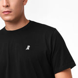 Black t-shirt with a small white logo worn by a person on a plain background