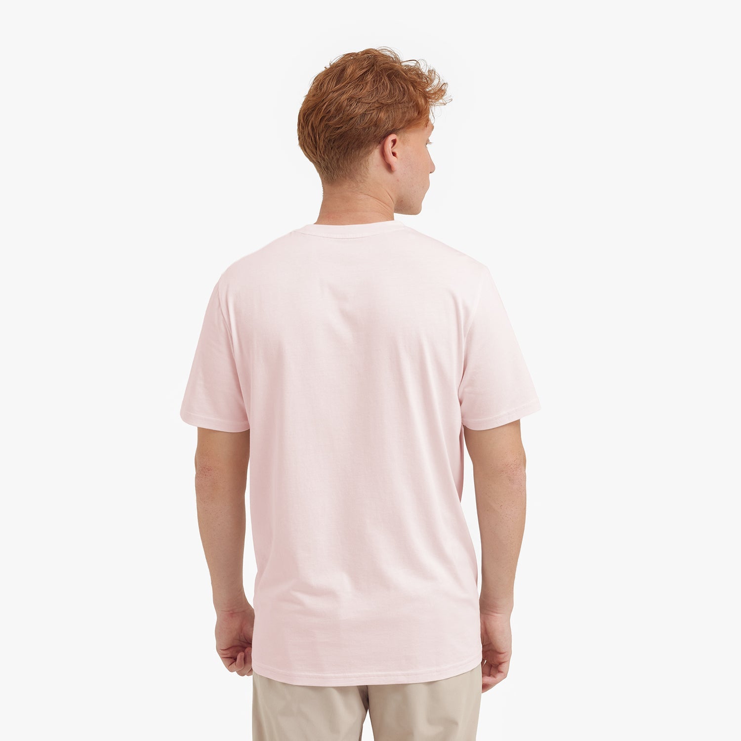 Back view of a man wearing a light pink t-shirt on a white background
