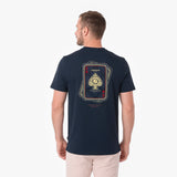 A man viewed from the back wearing a navy blue T-shirt with a large playing card graphic on the back