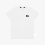 A white T-shirt with a small circular crest printed on the left chest. The inner collar features a contrasting navy blue trim, and a small black tag is visible near the bottom-right hem