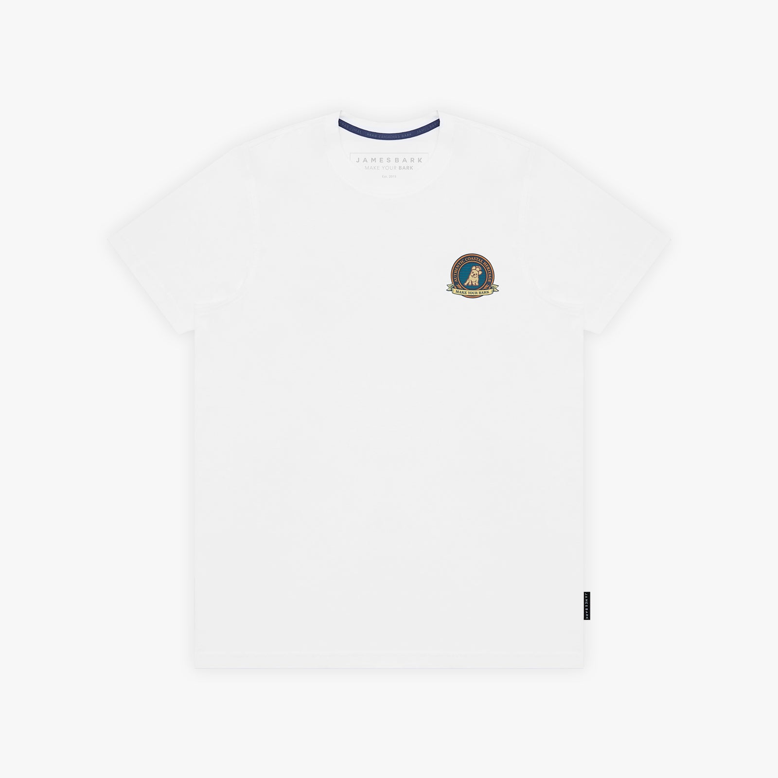 A white T-shirt with a small circular crest printed on the left chest. The inner collar features a contrasting navy blue trim, and a small black tag is visible near the bottom-right hem