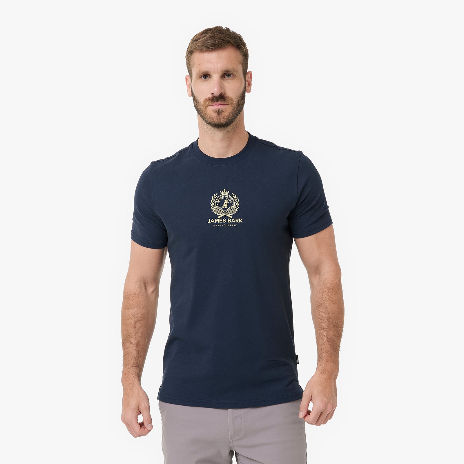 A man wearing a navy blue T-shirt with a gold James Park logo on the chest