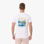 A man is viewed from behind, wearing a white T-shirt with a large graphic print on the back. The graphic features the text 'JAMES BARK' in yellow and blue, above an illustration of a yacht on blue water with mountains and a lighthouse.