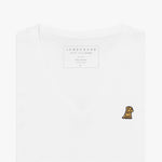 Close-up of a folded white v-neck t-shirt, showing the printed inner neck label "JAMES BARK, MAKE YOUR BARK, PIMA COTTON, MADE IN PERU, S" and a small yellow and black embroidered dog logo on the left chest