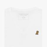 Close-up of a folded white v-neck t-shirt, showing the printed inner neck label "JAMES BARK, MAKE YOUR BARK, PIMA COTTON, MADE IN PERU, S" and a small yellow and black embroidered dog logo on the left chest