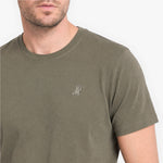 Man wearing a green t-shirt with a small logo on a white background