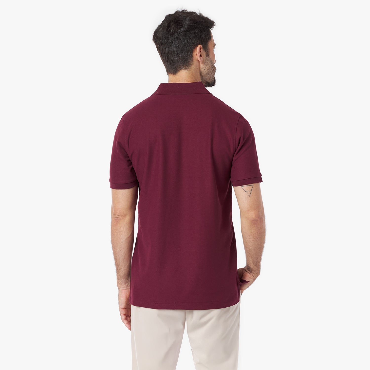 Back view of a man wearing a maroon polo shirt on a white background