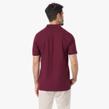 Back view of a man wearing a maroon polo shirt on a white background