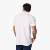 Back view of a man wearing a light pink polo shirt on a white background