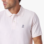 Close-up of a light pink polo shirt with a small white logo