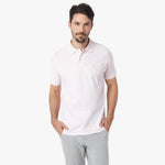 Man wearing a light pink polo shirt on a white background