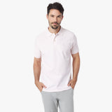 Man wearing a light pink polo shirt on a white background