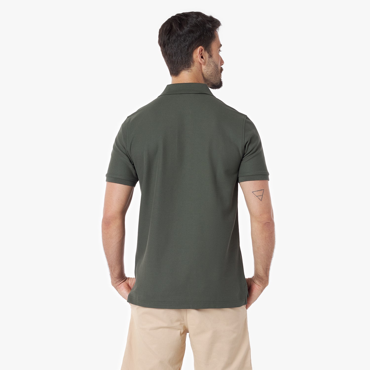 Back view of a man wearing a green polo shirt with a red logo