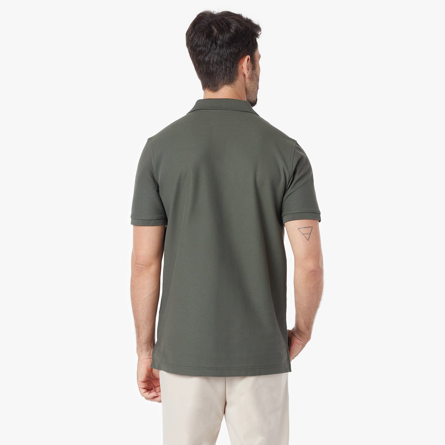 Back view of a man wearing a green polo shirt on a white background