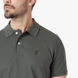 Close-up of a green polo shirt with a small logo on a white background