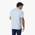 Back view of a man wearing a light blue polo shirt on a white background