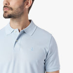 Close-up of a light blue polo shirt with a small logo on a white background