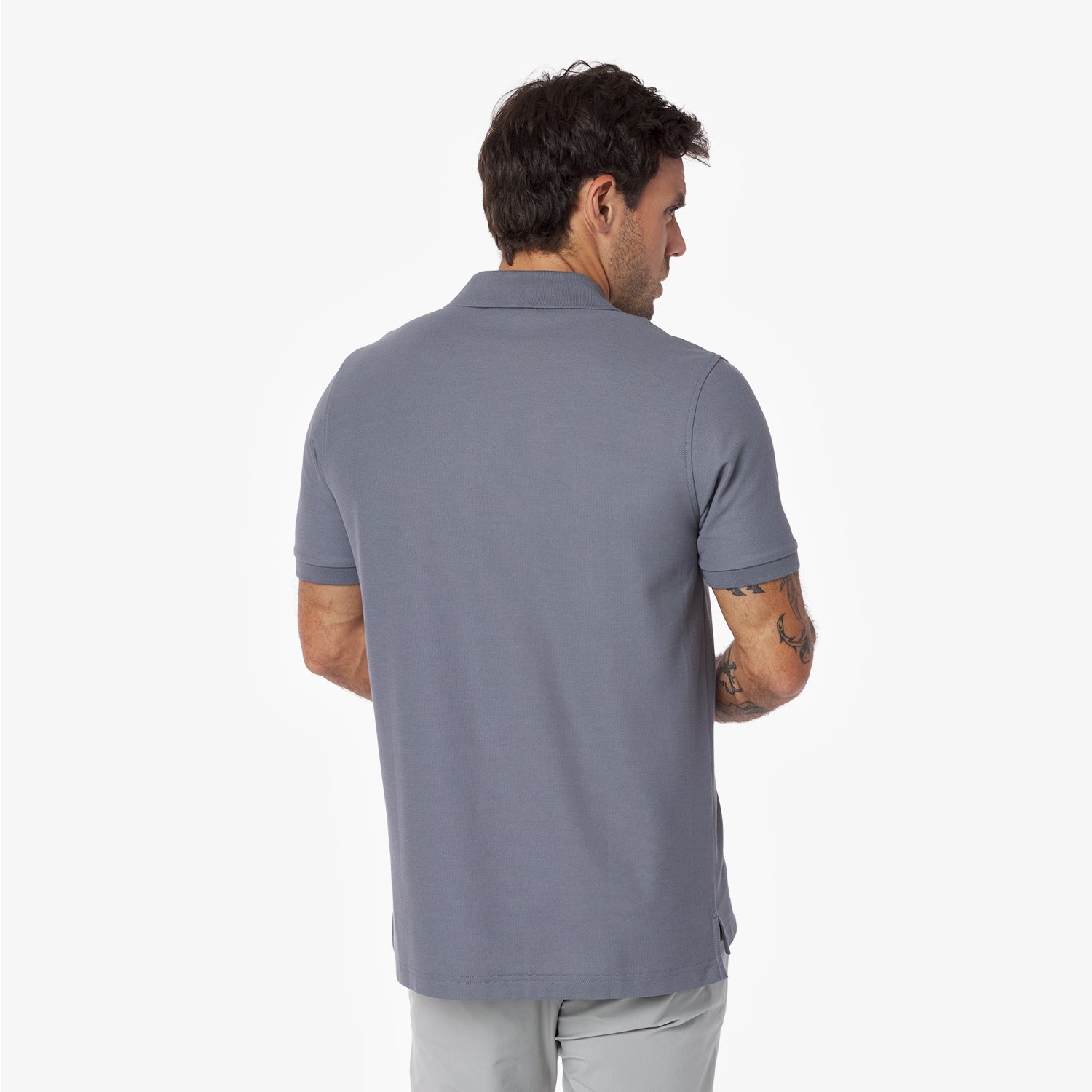 Back view of a man wearing a gray polo shirt on a white background