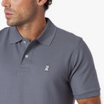 Close-up of a gray polo shirt with a small logo on a white background