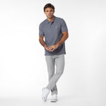 Man wearing a gray polo shirt and light gray pants on a white background