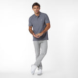 Man wearing a gray polo shirt and light gray pants on a white background