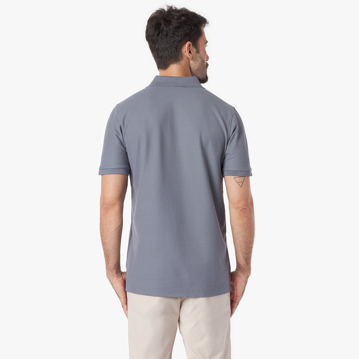 Back of a man wearing a gray polo shirt on a white background