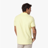Back view of a man wearing a light yellow polo shirt on a white background