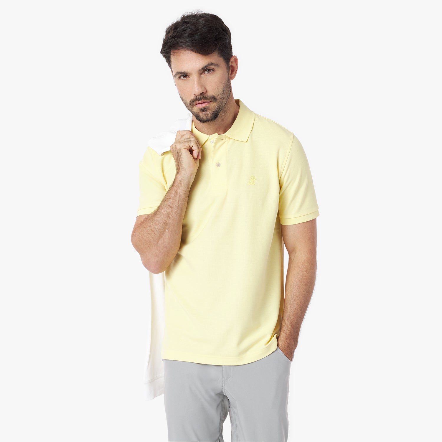 Man wearing a light yellow polo shirt on a white background