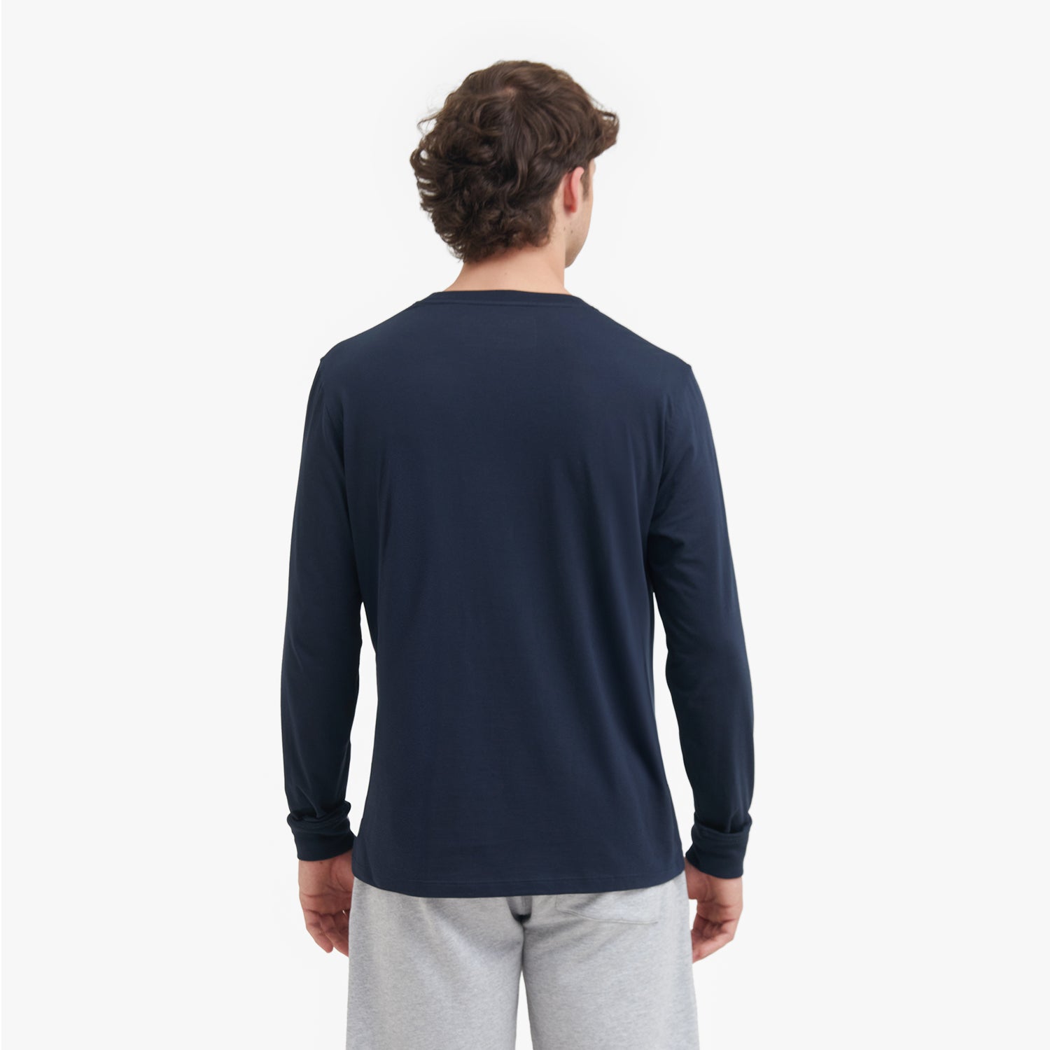 Man wearing a navy long-sleeve shirt on a white background