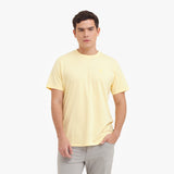 Man wearing a light yellow t-shirt on a white background