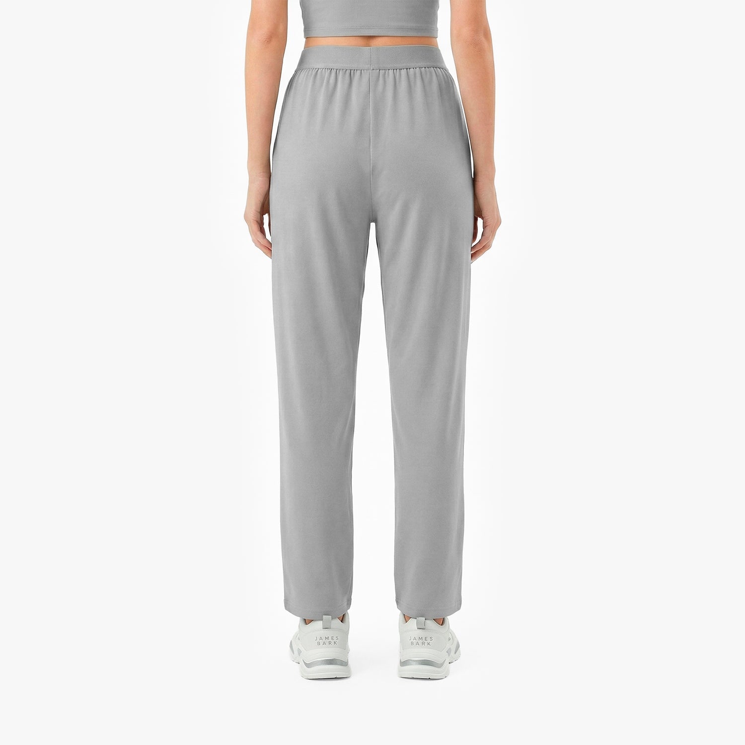 Person wearing gray high-waisted pants on a white background
