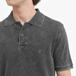 Close-up of a gray polo shirt with a small logo on a white background