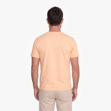 Man wearing a light yellow t-shirt and beige pants on a white background