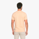 Man wearing a light peach T-shirt and beige pants 
