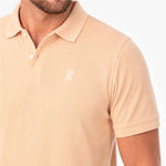 Beige polo shirt with a small logo on a white background
