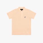 A light peach-pink polo shirt for kids, featuring a small navy embroidered dog logo on the left chest, set against a plain white background.