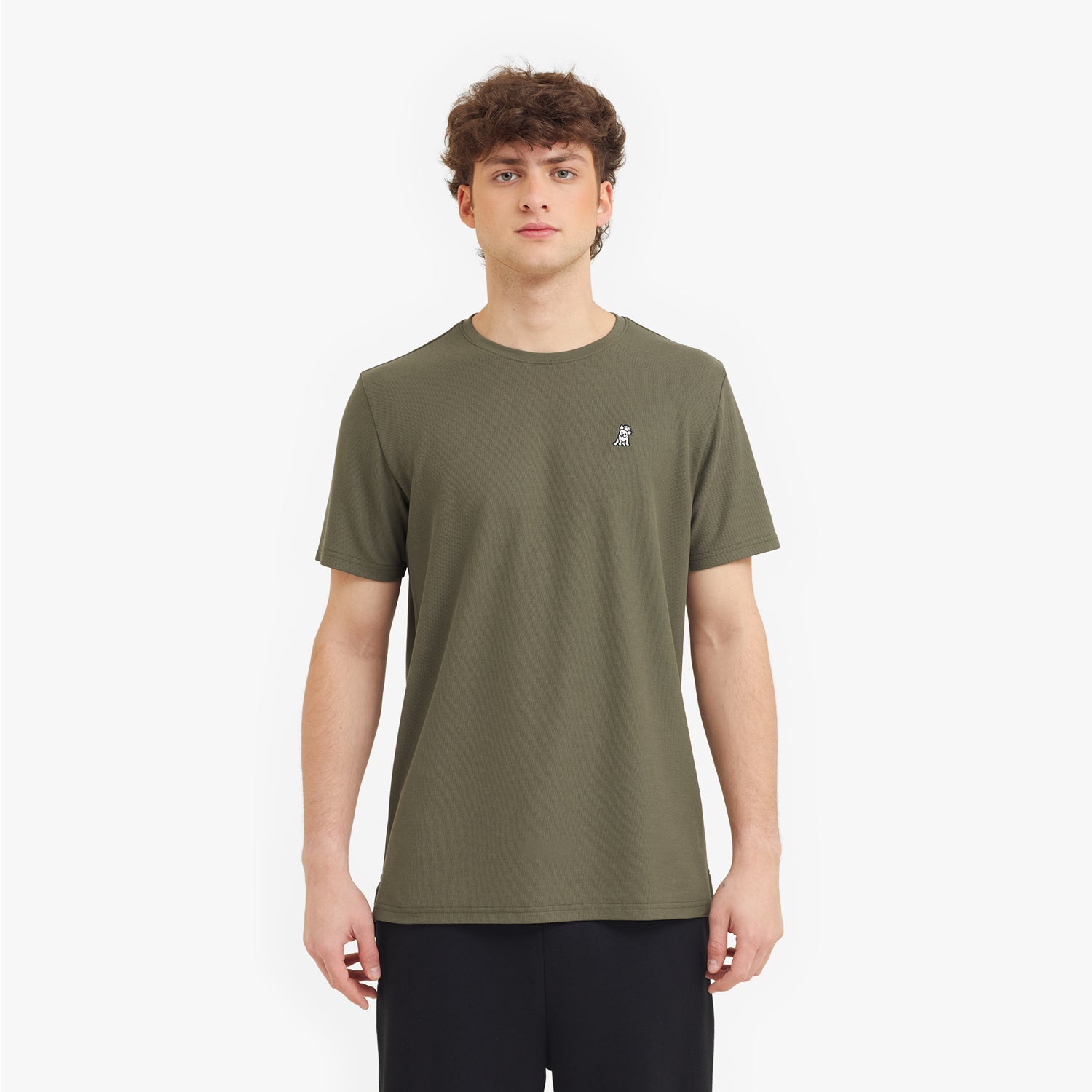 Man wearing a green t-shirt with a small logo on a white background