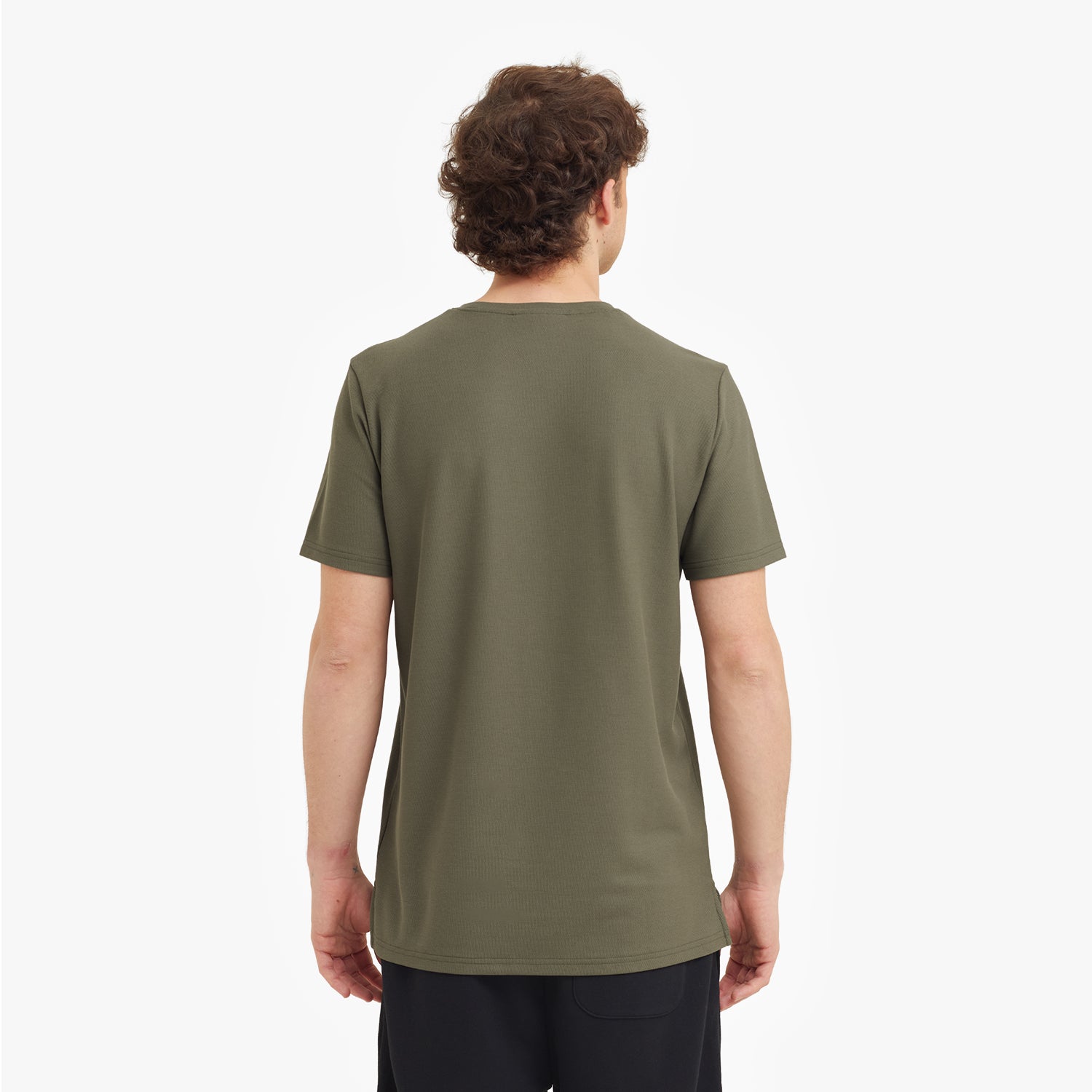 Back view of a man wearing a green t-shirt on a white background