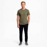 Man wearing a green t-shirt and black pants on a white background