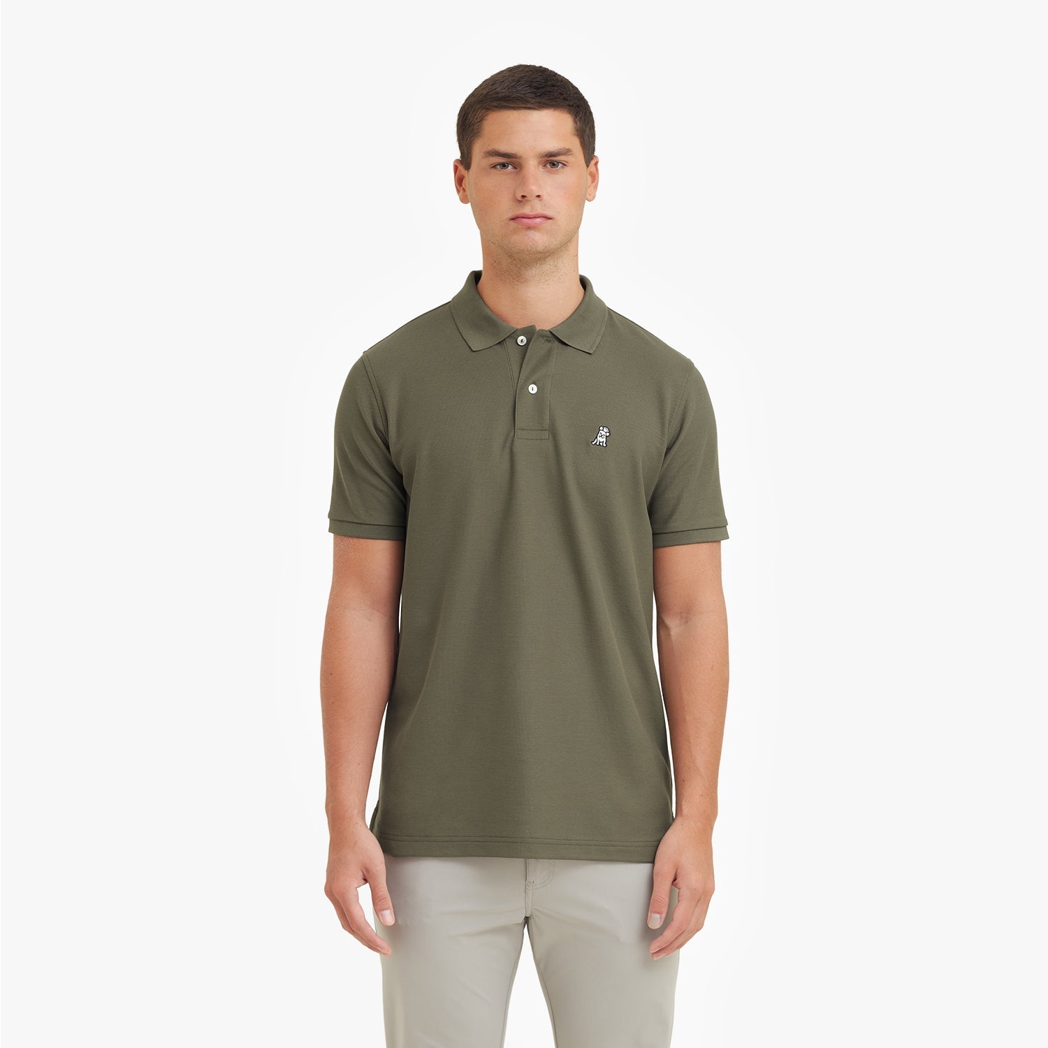 Man wearing a green polo shirt with a small logo on a white background
