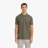 Man wearing a green polo shirt with a small logo on a white background