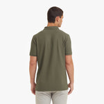 Back view of a man wearing a green polo shirt on a white background